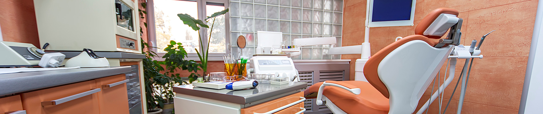 The image shows a modern dental clinic interior with various pieces of equipment, including a dental chair and an X-ray machine.