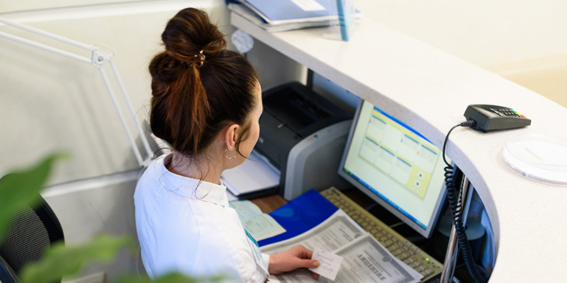 A person sitting at a computer desk in an office setting.