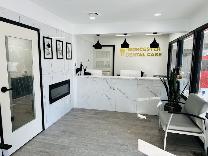 The image shows an interior view of a dental office with modern furnishings, including a reception desk, countertop, chair, and a sign that reads  Worcester Dental Care.